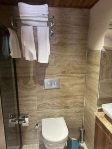 a bathroom with a toilet and a sink and towels at Babilyon Otel in Urfa +58 photos