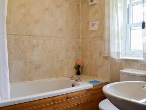 a bathroom with a tub and a toilet and a sink at Swaledale Cottag in Caldbeck +12 photos