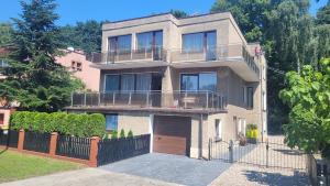 ein großes Haus mit Garage und Zaun in der Unterkunft Apartament "Przez las na plażę" in Świnoujście