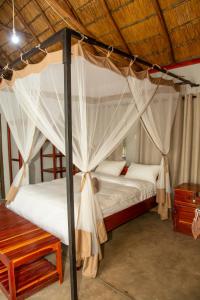 a bedroom with two beds with mosquito nets at Oxpecker Safari Lodge  +44 photos