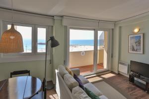 a living room with a couch and a view of the beach at Hotel Apartamento Solverde in Espinho