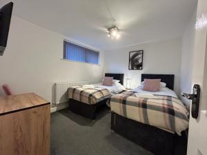 a room with two beds and a desk in it at Lovely refurbished apartments, Morecambe Promenade in Morecambe