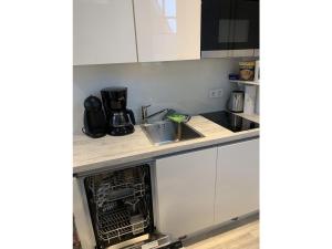 a kitchen with white cabinets and a sink at Koje in Sankt Peter-Ording