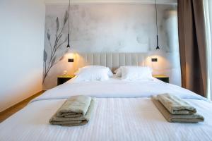 a bedroom with two towels on a white bed at Villa Providenca - Makarska Exklusiv in Tučepi +17 photos