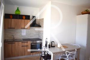 a small kitchen with a counter and a table at Essenza Rooms in Crispiano