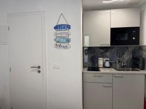 a kitchen with white cabinets and a sign that reads life is better in the kitchen at Morski Val in Piran +13 photos