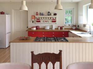 cocina con fogones y encimera roja en Owl Cottage, en Kilmote