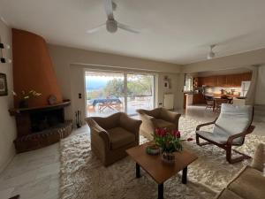 ein Wohnzimmer mit Sofa und Stühlen und einem Kamin in der Unterkunft Seaview Haven in Kap Sounion
