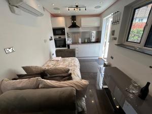 a living room with a couch and a kitchen at Studio Guest House in Great Barr