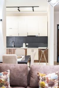 Una sala de estar con un sofá y una cocina. en Palm Suites Apartments, en Vlorë