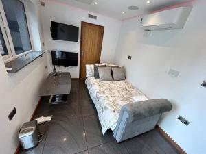a bedroom with a bed and a desk and a television at Studio Guest House in Great Barr