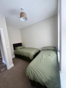 Un dormitorio con dos camas y una lámpara. en The Meads, en Ilfracombe