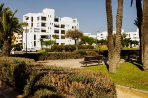 a park with a bench in front of a building at Gaviotas Playa in Almerimar