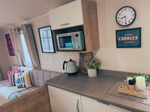 a kitchen with a counter and a microwave in a caravan at Sandy Nights in Tywardreath