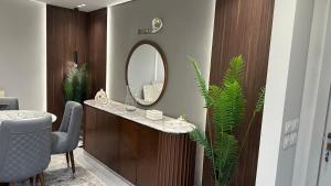 a bathroom with a vanity with a mirror and plants at Marwa Galal in Abū Rawwāsh