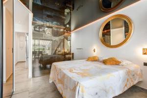 a bedroom with a large bed and a mirror at AmbassadOr Elegance and comfort steps from the naturist beach in Cap d'Agde