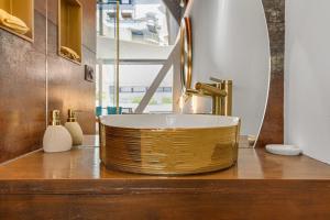 a bathroom with a gold sink on a counter at AmbassadOr Elegance and comfort steps from the naturist beach in Cap d'Agde +15 photos