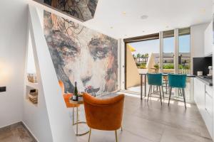 a living room with a large painting on the wall at AmbassadOr Elegance and comfort steps from the naturist beach in Cap d'Agde