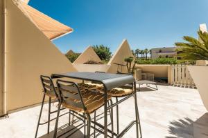 a table and chairs on top of a patio at AmbassadOr Elegance and comfort steps from the naturist beach in Cap d'Agde