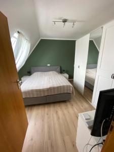 a bedroom with a bed and a desk with a television at Gemütliche Wohnung in Xanten