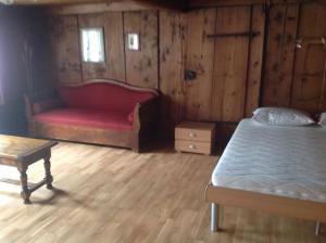 a bedroom with a bed and a table and a bench at Appartement La Croix in Villarvolard