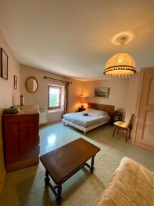 a bedroom with a bed and a table in it at Maison du Rocher Veynes - 2 à 4 personnes - Draps et Serviettes fournies in Veynes