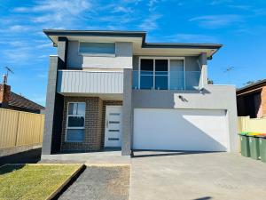 una casa con dos puertas blancas de garaje en Cozy & Spacious 5BR Family Home with Free On-Site Parking, en Pendle Hills