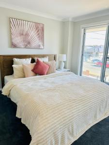 Un dormitorio con una cama grande con una ventana grande. en Cozy & Spacious 5BR Family Home with Free On-Site Parking, en Pendle Hills
