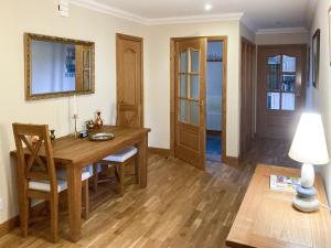 Un comedor con mesa y sillas de madera. en Sandy Beach, en Nairn