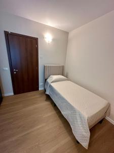 Habitación pequeña con cama y puerta de madera en Residenza Degiuli, en Domodossola
