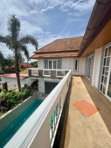 Blick auf den Balkon eines Hauses mit Swimmingpool in der Unterkunft Amazing 4BR pool villa near beach Bangtao in Ban Thalat Choeng Thale