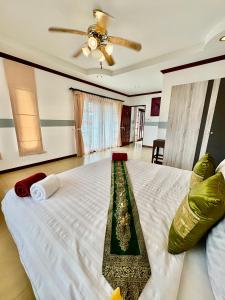 ein Schlafzimmer mit einem großen Bett mit Decke in der Unterkunft Amazing 4BR pool villa near beach Bangtao in Ban Thalat Choeng Thale