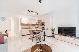 cocina y sala de estar con mesa y TV en Stylish 2BR Escape in St Julians, en San Julián