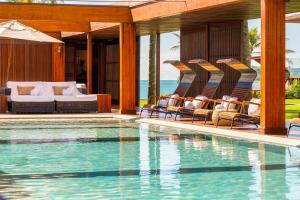 un resort con piscina e sedie a sdraio vicino all'oceano di Zendaya Resort Beach Sport & Spa a Búzios