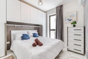 Un dormitorio con una gran cama blanca con almohadas azules. en Stylish 2BR Escape in St Julians, en San Julián