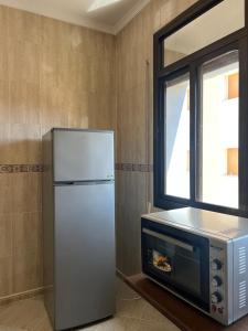 a refrigerator and a microwave in a kitchen at Vancouver appartement in Nador