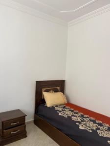 a small bedroom with a bed and a nightstand at Vancouver appartement in Nador