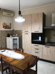 a kitchen with a wooden table and a dining room at Residenza delle Rose in Lamezia Terme