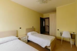 a hotel room with two beds and a desk at Guest House Le Risaie in Asigliano Vercellese