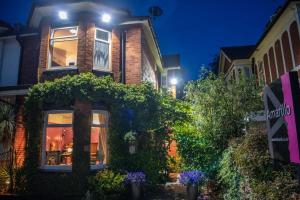 a building with ivy on the side of it at night at Amarillo in Bournemouth