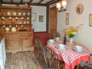 a dining room with a table with a red and white table cloth at Henley Bridge Holiday Cottage in Ashburnham