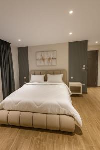 - une chambre avec un grand lit et un couvre-lit blanc dans l'établissement pyramids heaven inn, à Giza