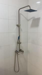 a shower with a shower head on a white wall at 4 bedroom apartment in Igaun