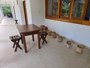 a table and benches in a room with baskets on the floor at Hotel Serugahawatta in Wellawaya +29 photos
