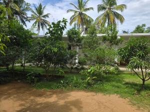 a building with trees in front of a yard at Hotel Serugahawatta in Wellawaya