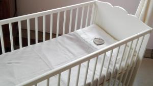 Białe łóżeczko z zegarem na nim w obiekcie Sweet Home w mieście Faggeto Lario 