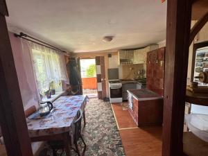 a kitchen with a table in the middle of a room at Родинна оселя in Slavske