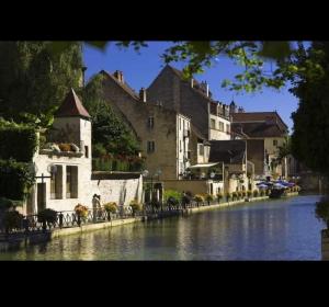 a group of buildings next to a river at Le Nid Dolois in Dole