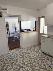 a kitchen with a counter and a dining room with a table at Le Nid Dolois in Dole +5 photos