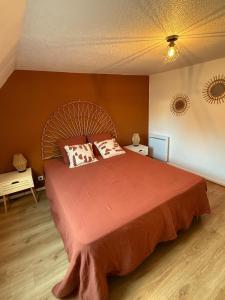 a bedroom with a large orange bed with two pillows at Le Nid Dolois in Dole +5 photos